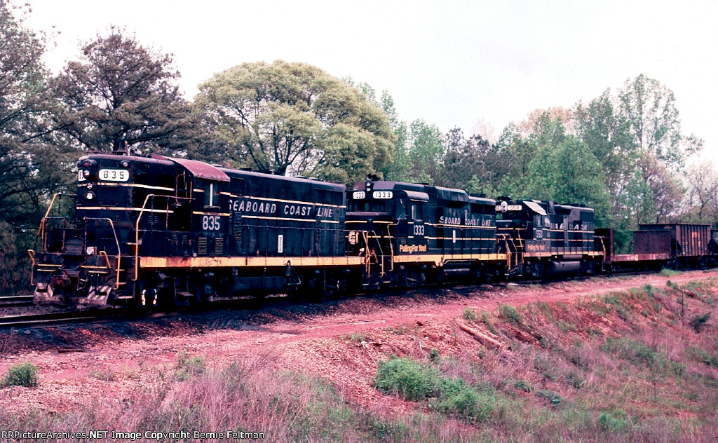 Seaboard Coast Line GP7 #835 leads GP30 #1333 and GP38-2 #550, elephant style, with SCL train # 510, a Fitzgerald to Manchester do-everything local, tied down in the siding after crew went on the law